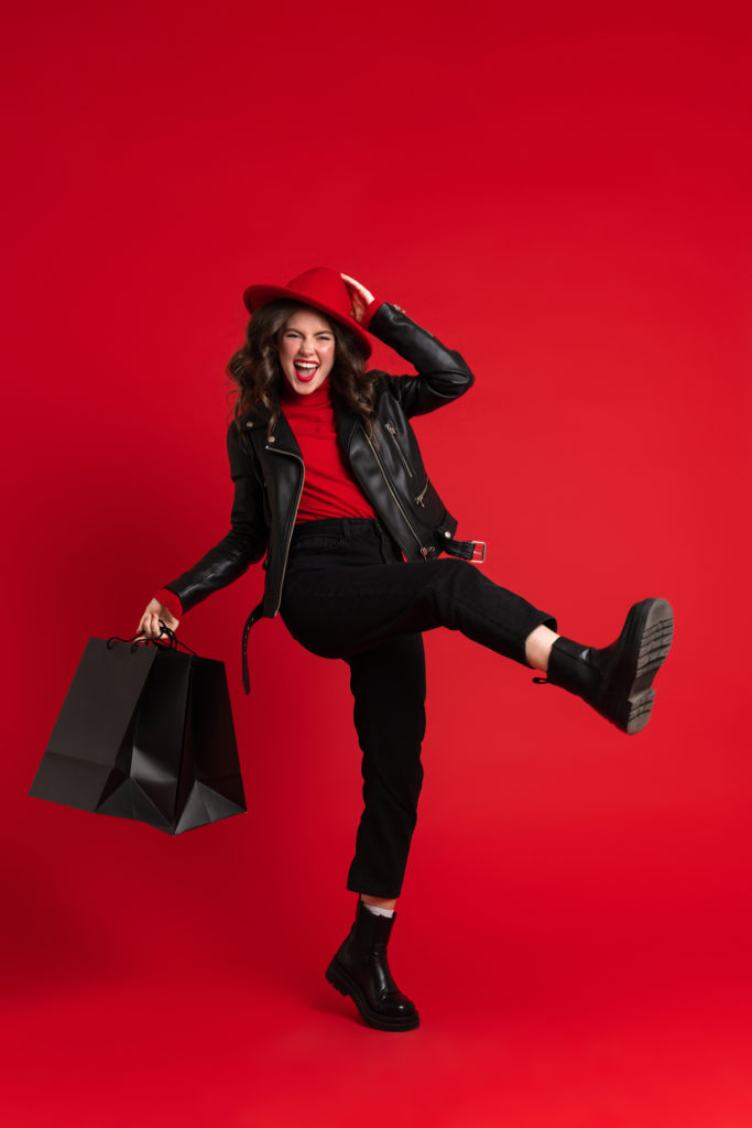 White,Woman,Laughing,While,Posing,With,Shopping,Bags,Isolated,Over